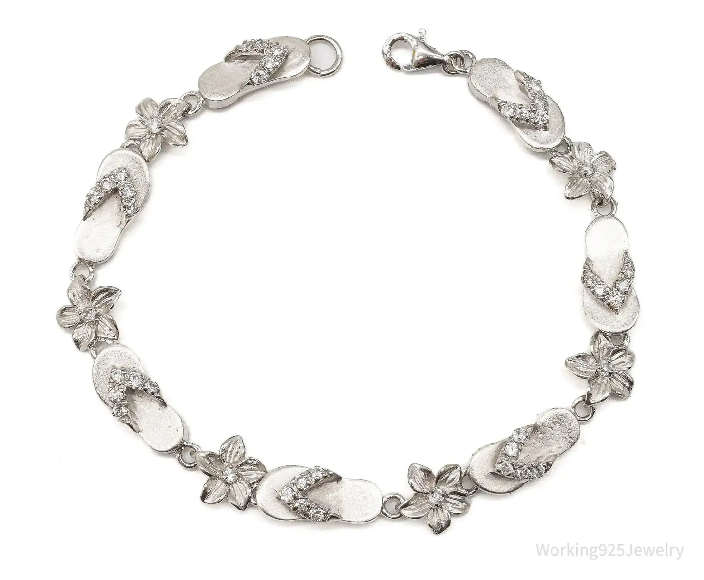 Sterling silver vintage bracelet with cubic zirconia sandals and flower designs, featuring intricate jewelry craftsmanship.