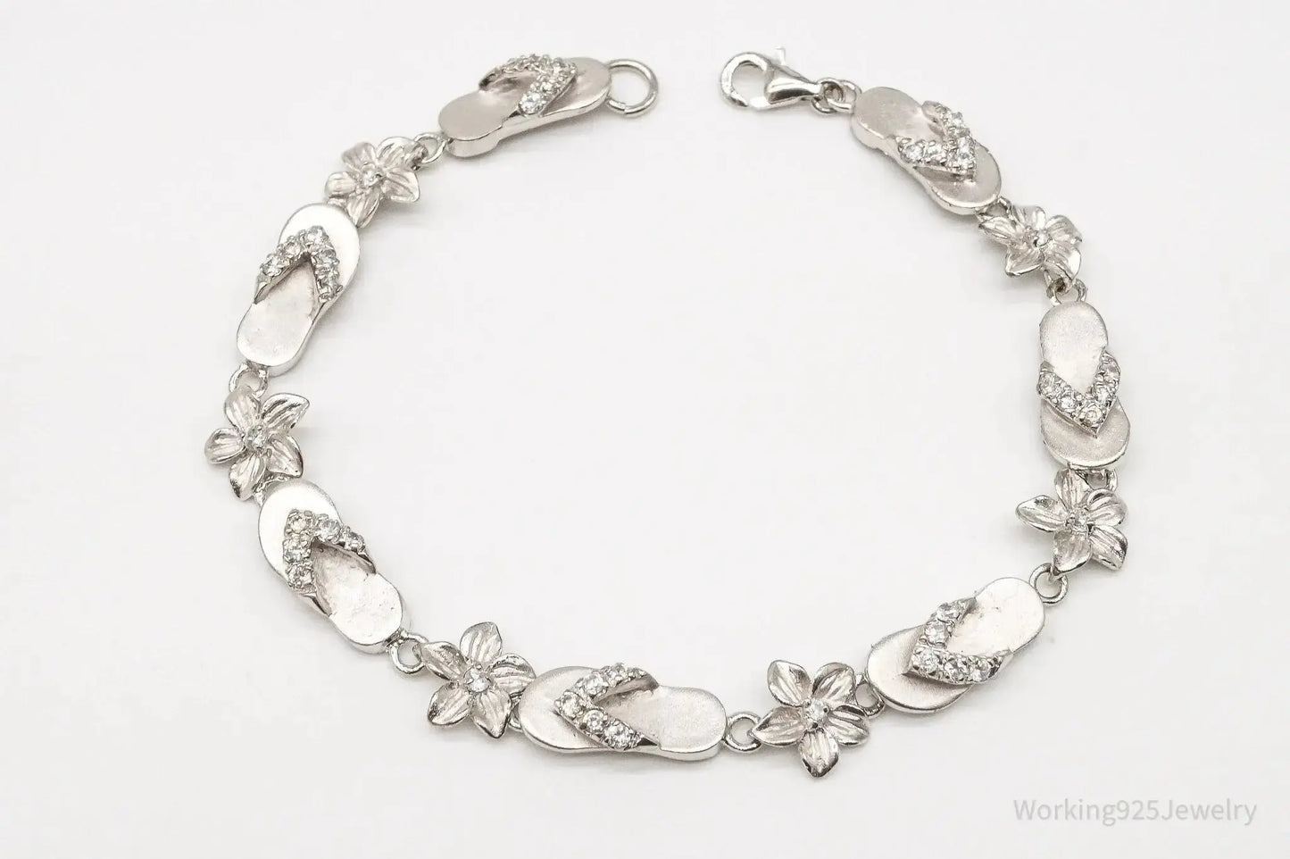 Sterling silver vintage bracelet with cubic zirconia sandals and flower designs, crafted by Plush Fashion Hub.