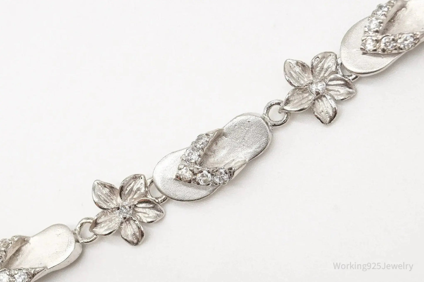 Sterling silver vintage bracelet featuring cubic zirconia sandals and flower charms, crafted by Plush Fashion Hub.