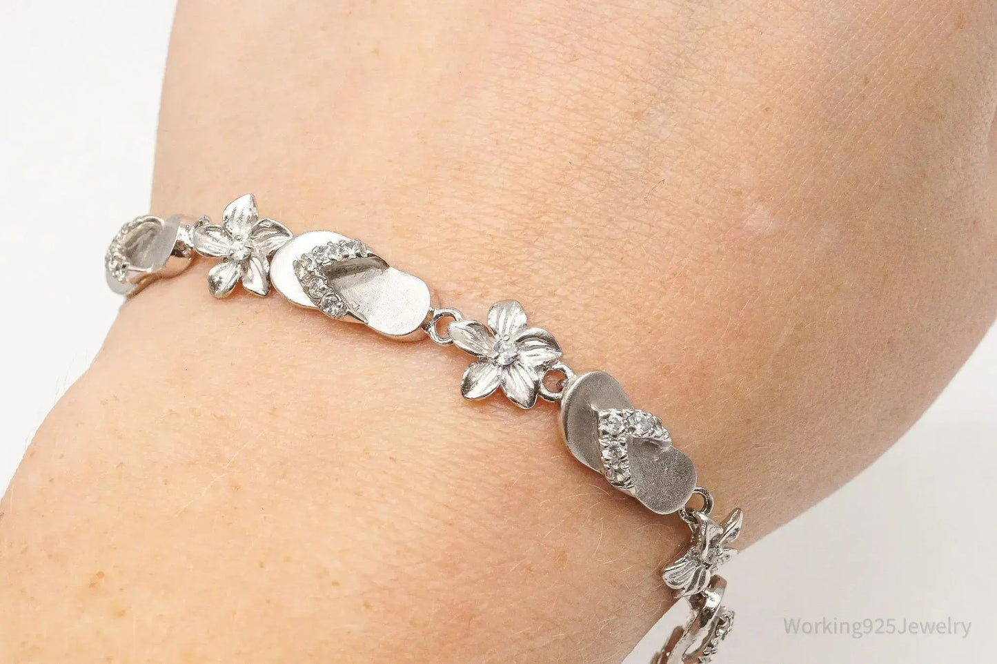 Sterling silver vintage bracelet with cubic zirconia sandals and flower designs, featuring elegant jewelry craftsmanship.