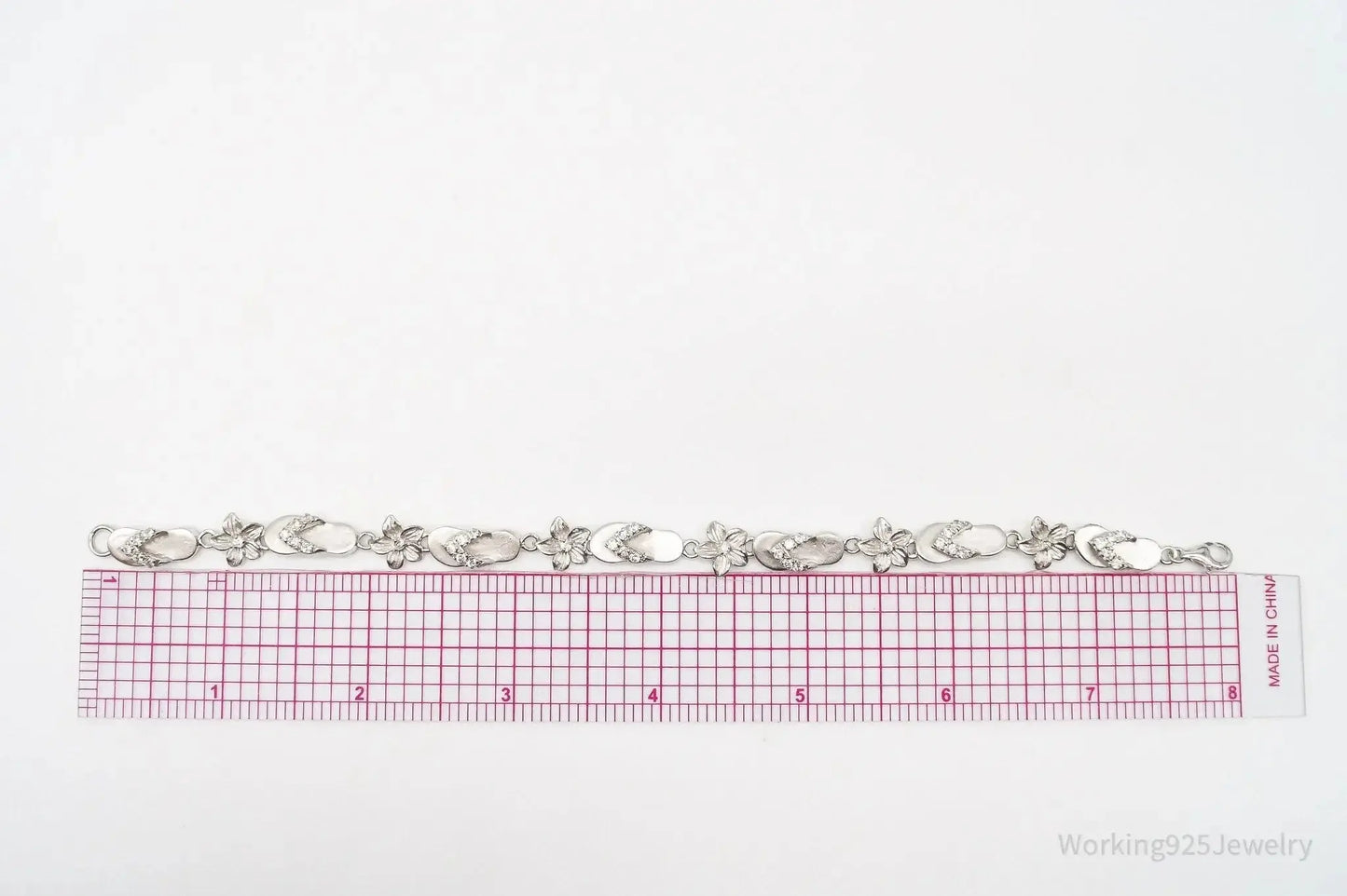 Sterling silver vintage bracelet featuring cubic zirconia sandals and flower charms, stylish jewelry from Plush Fashion Hub.