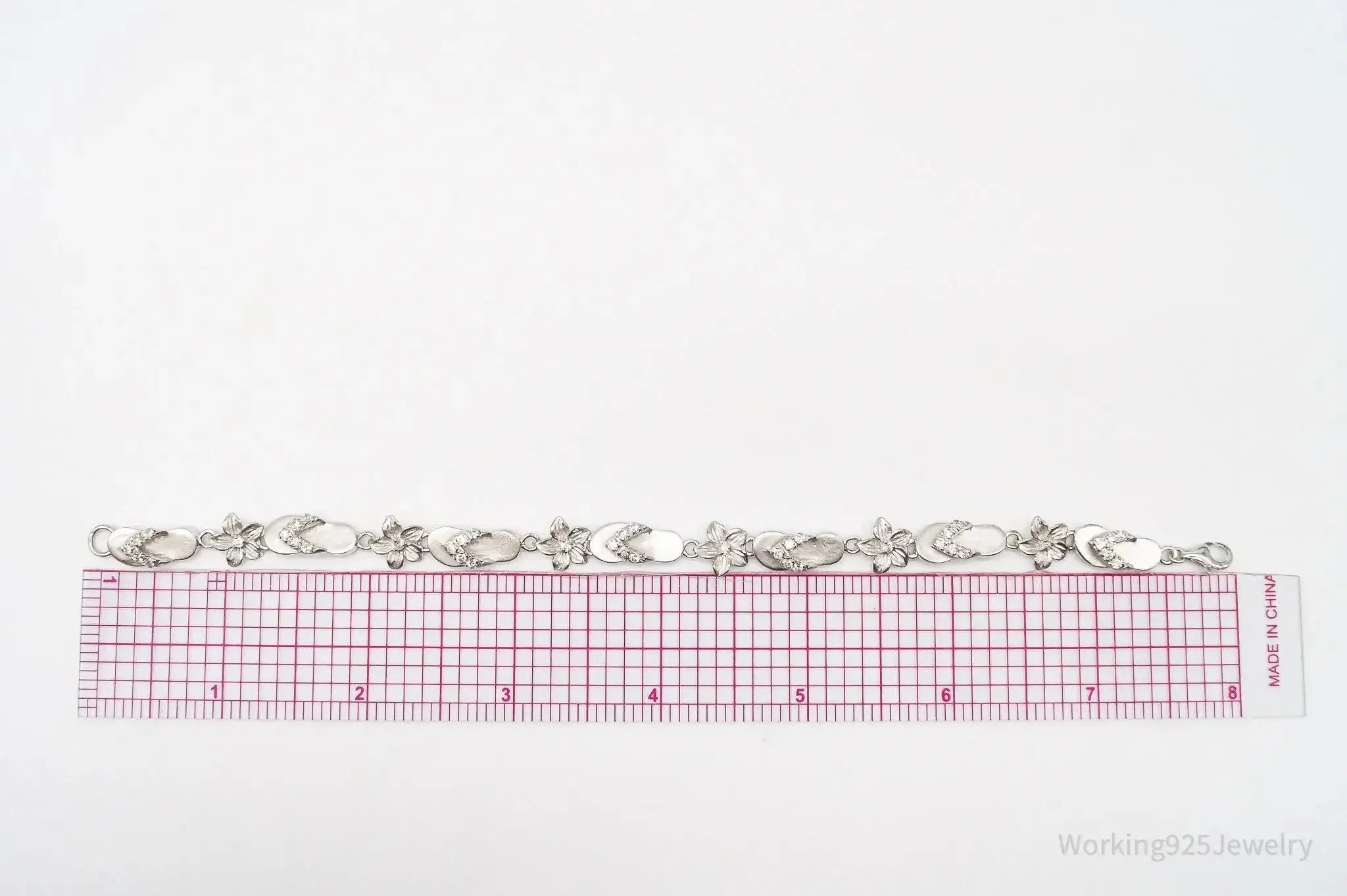 Vintage Sterling Silver Bracelet with floral and cubic zirconia accents, showcasing intricate jewelry design.
