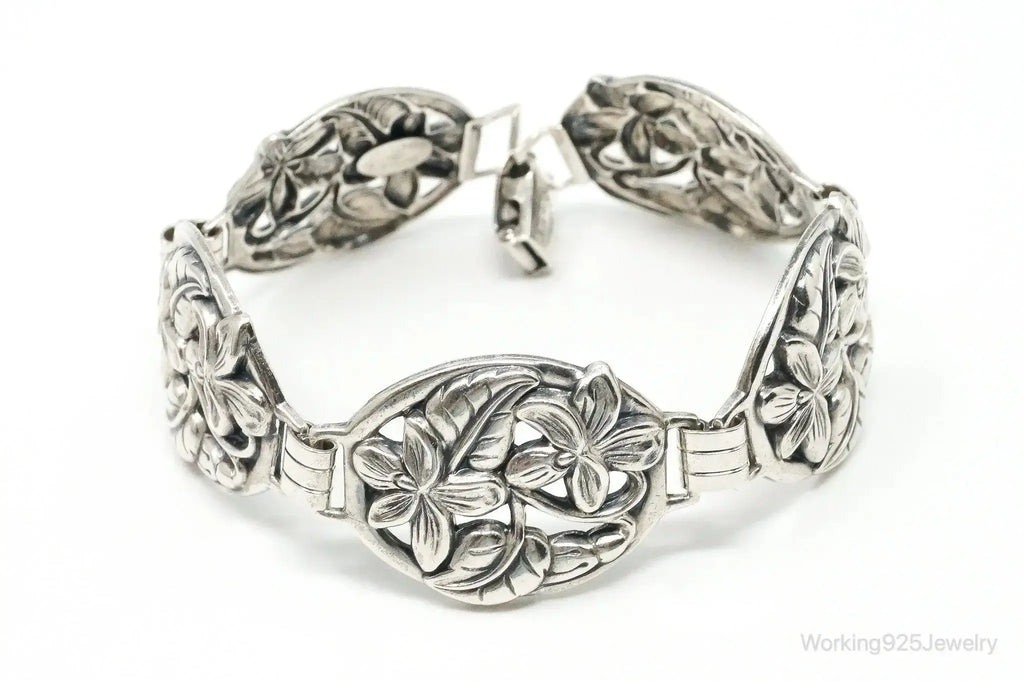 Vintage Danecraft sterling silver bracelet with floral panel design, featuring intricate craftsmanship and elegant jewelry styling.