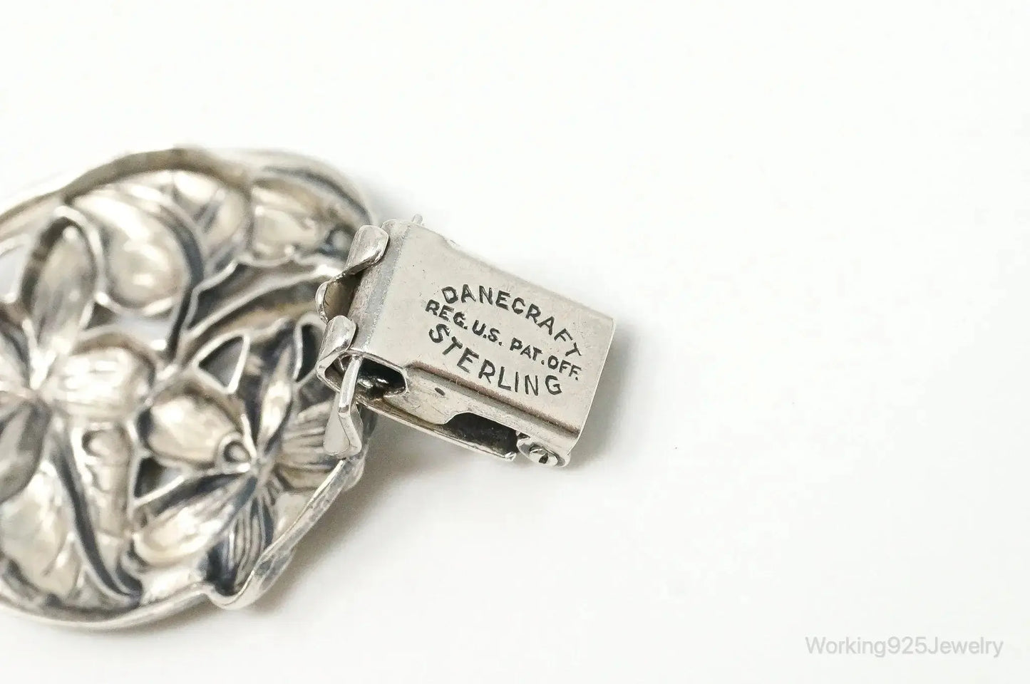 Vintage Danecraft sterling silver floral panels bracelet, showcasing intricate floral designs in jewelry style.