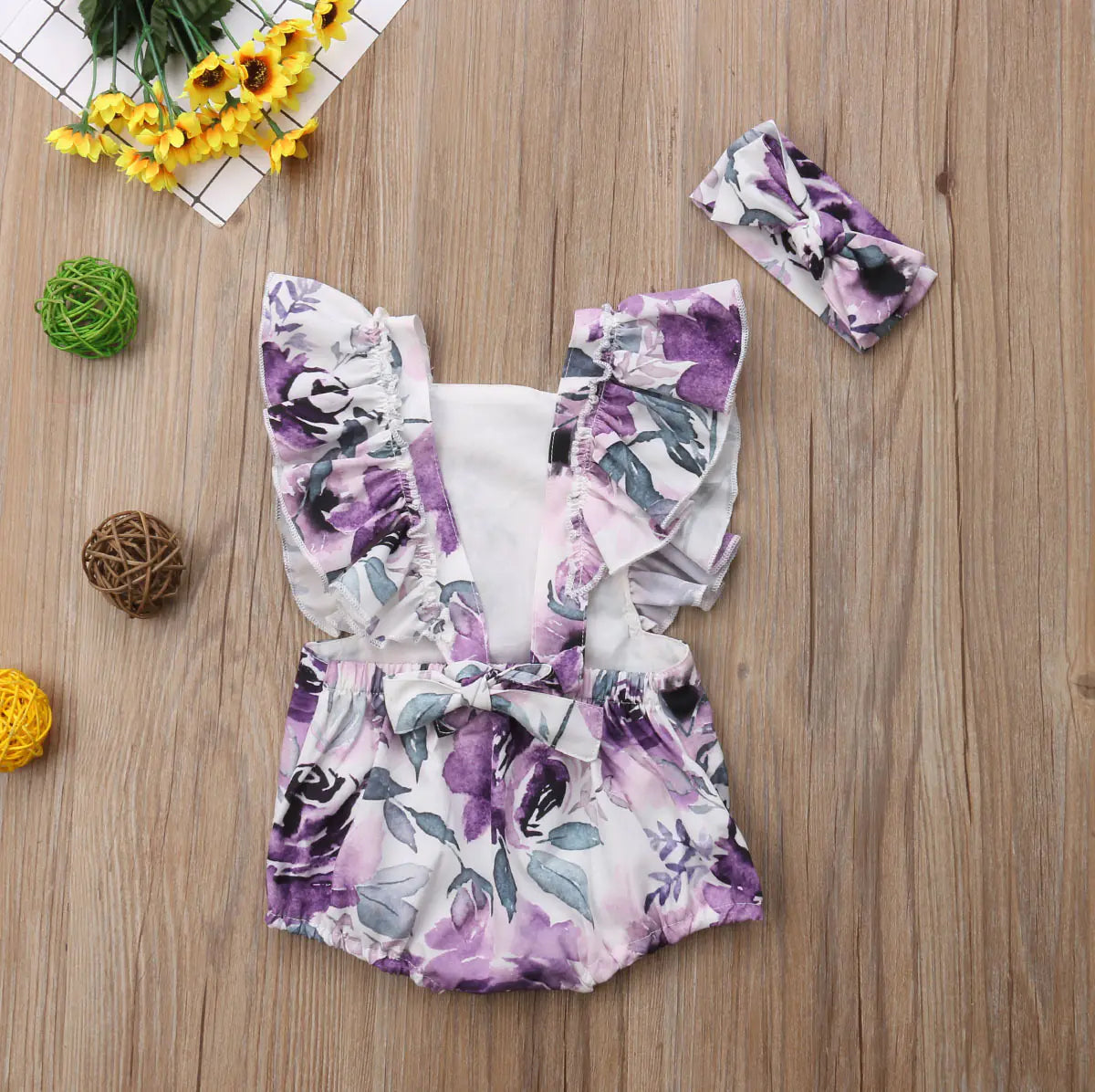 Girls' floral two-piece outfit with back tie and matching headband, stylish and cute for warm weather.