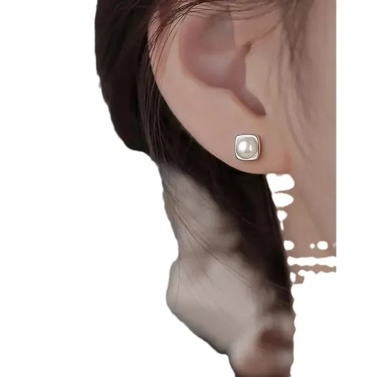 Elegant minimalist 925 sterling silver pearl stud earrings featuring geometric design, perfect for sophisticated women.