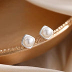 Sterling silver pearl stud earrings with minimalist geometric design, elegant jewelry for women.