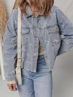 Women's light wash denim jacket with bow knot print and raw hem from Trendsi, showcasing the stylish design and casual fit.
