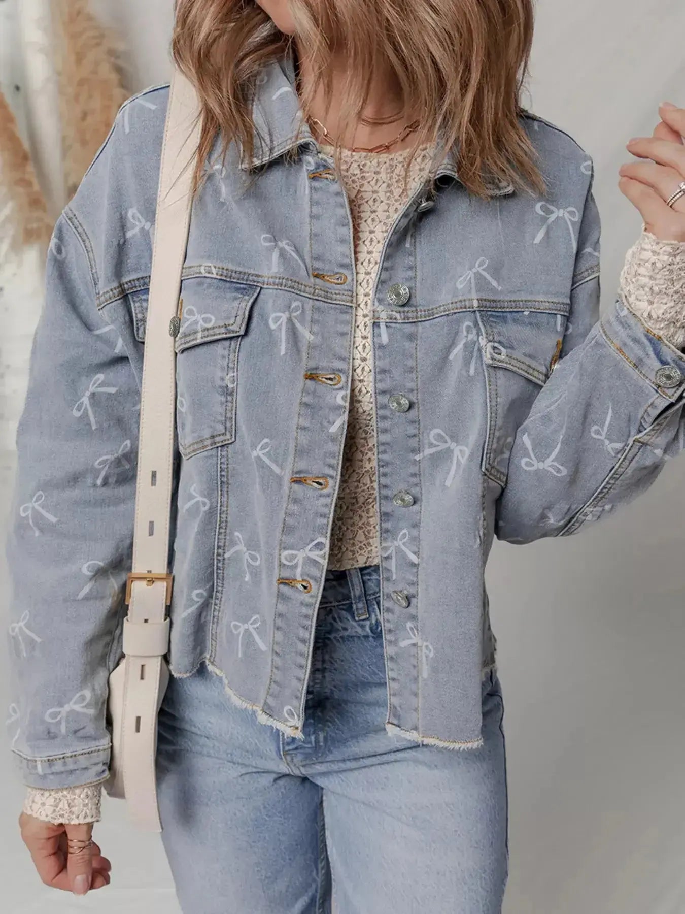 Women's light wash denim jacket with bow knot print and raw hem, stylish Trendsi denim jacket for casual wear