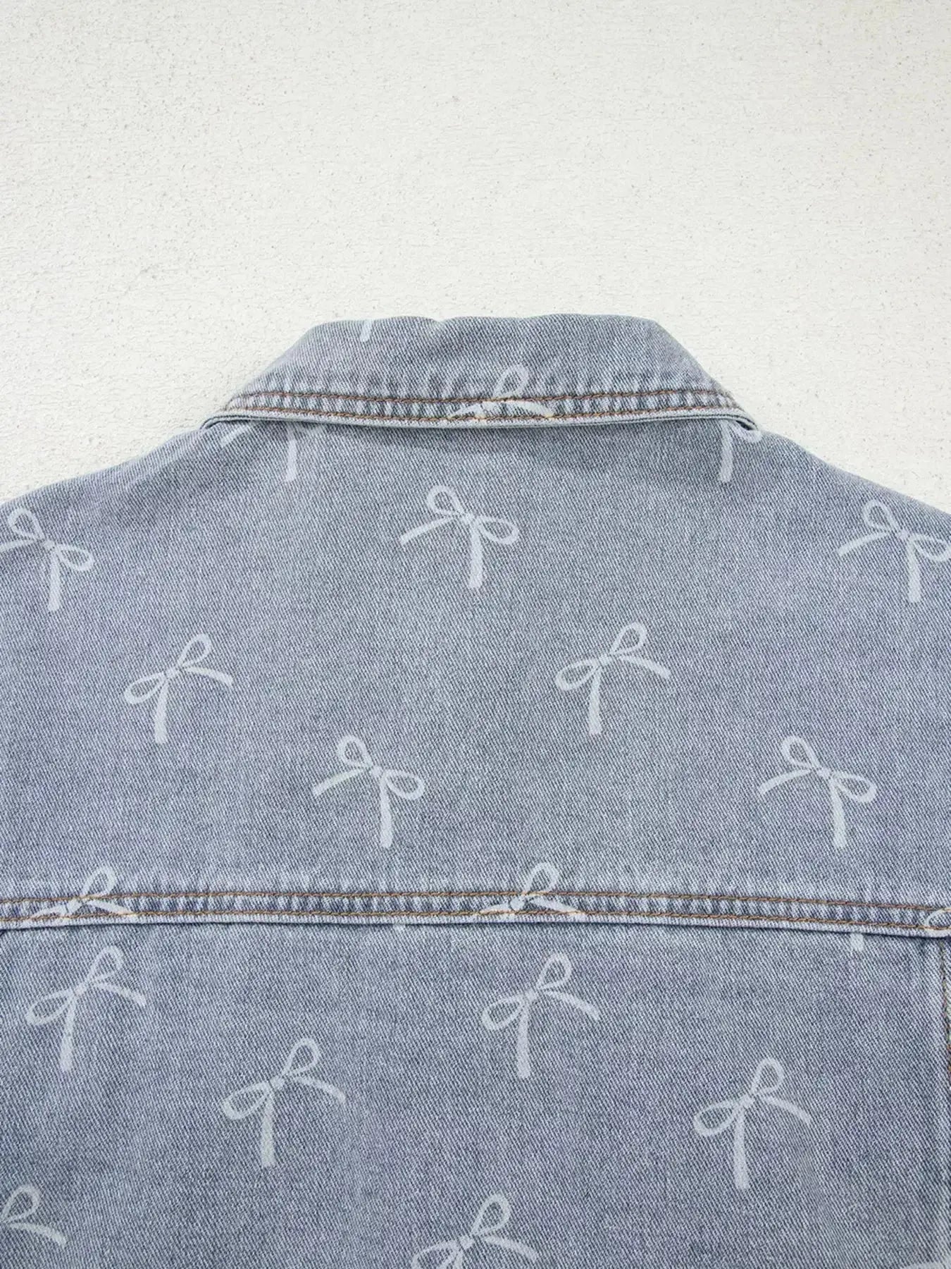 Light wash denim jacket with bow knot print, raw hem, and classic fit, designed for women by Trendsi.