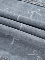 Women's light wash denim jacket with bow knot print and raw hem from Trendsi, styled with front view and casual fit.