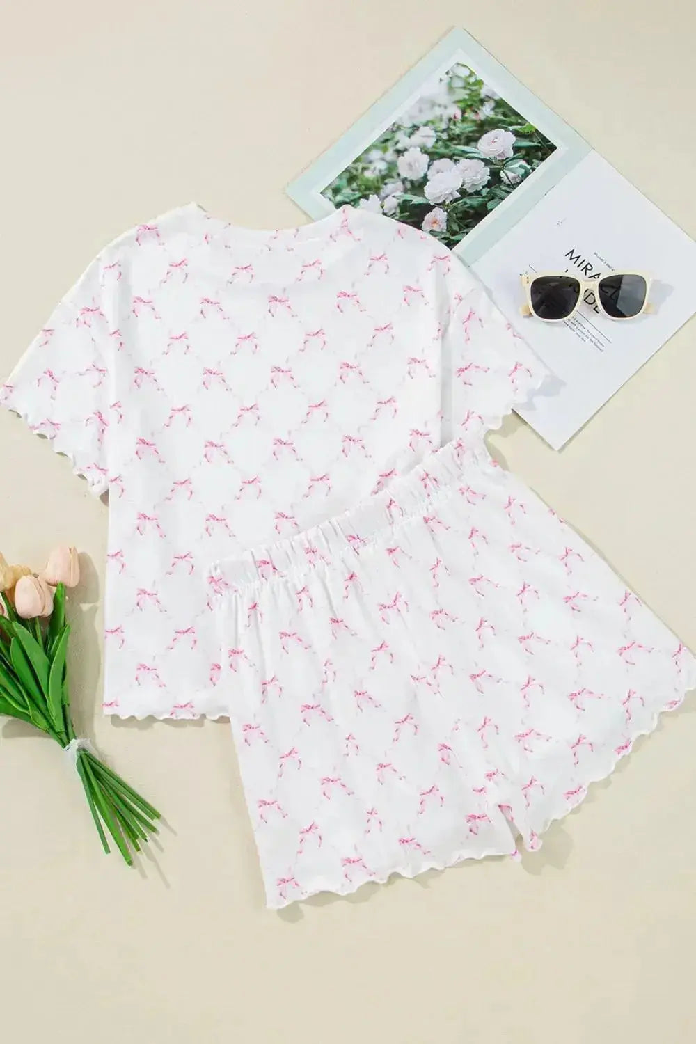 Women’s bow print lettuce trim lounge set by Trendsi, soft pajama top and shorts featuring playful bow pattern and comfortable fit.