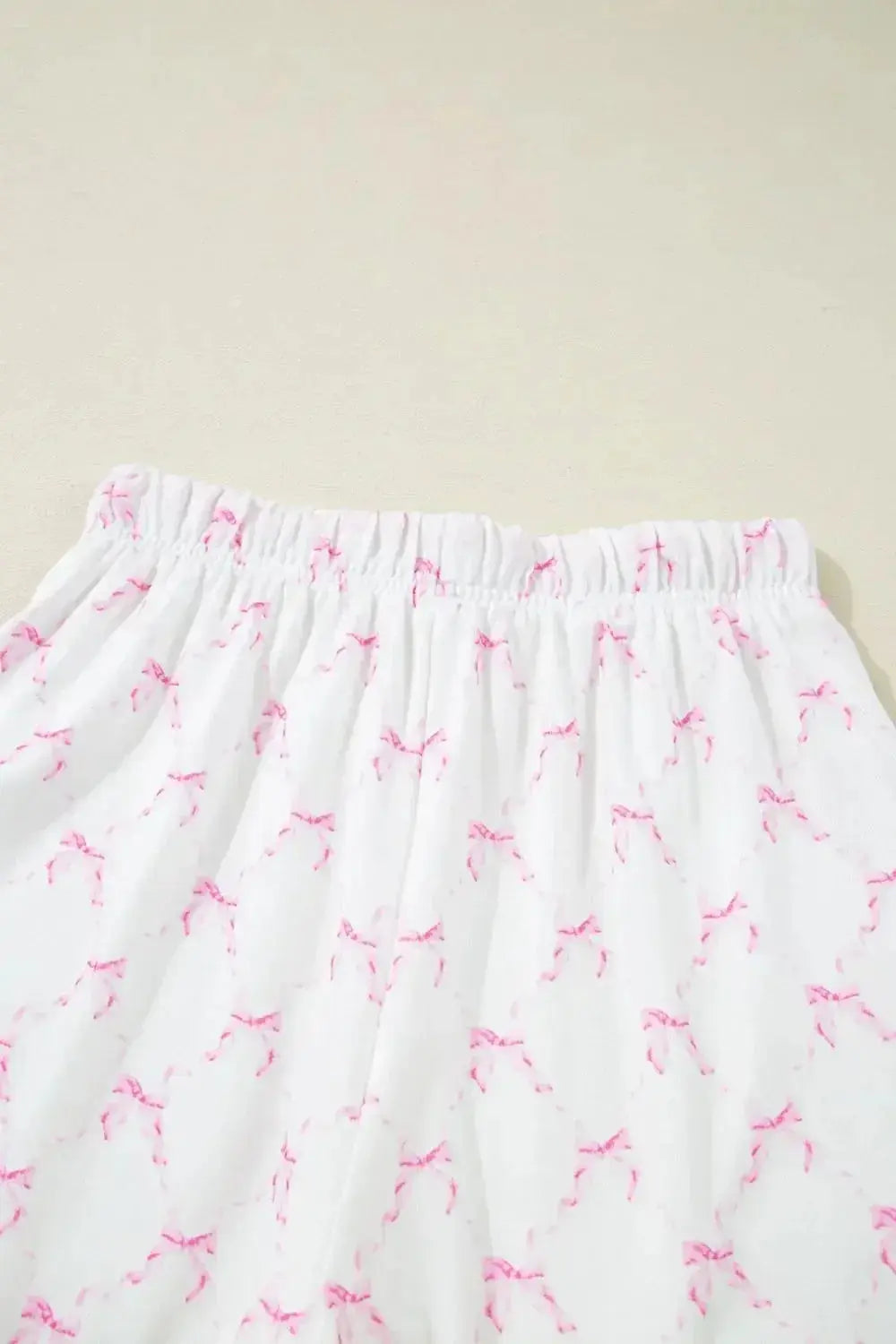 Women's bow print lounge set by Trendsi featuring lettuce trim, soft pajama top and shorts for comfortable wear.