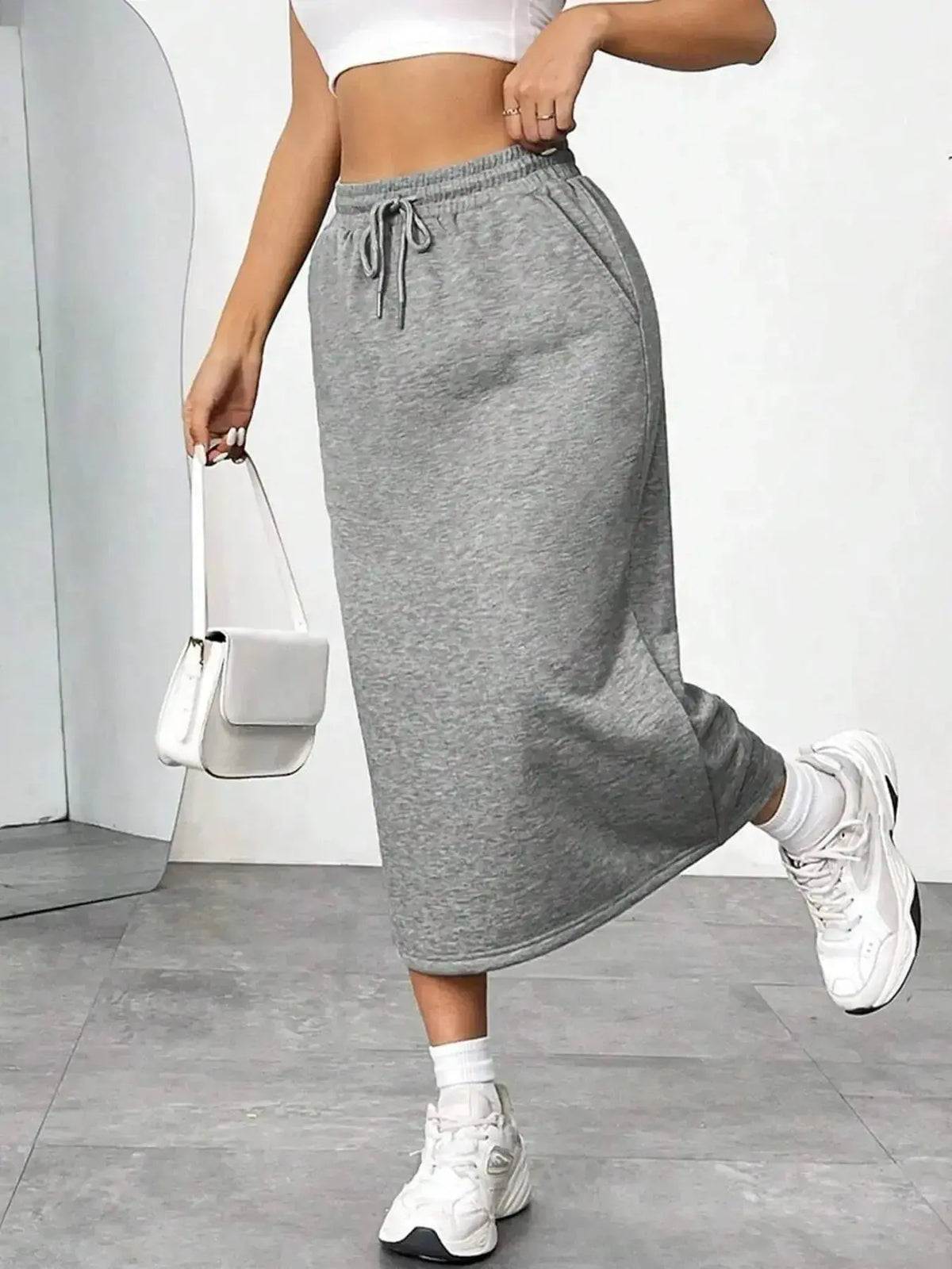 Women’s casual drawstring midi skirt by Plush Fashion Hub with pockets and side slit, styled for everyday wear.