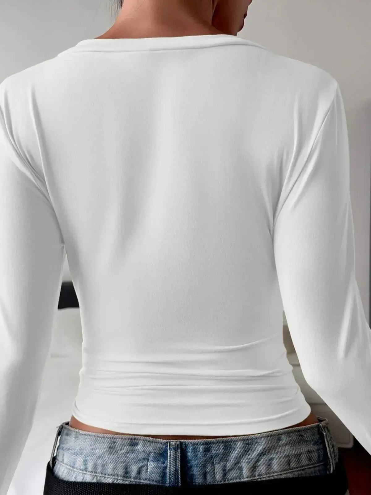 Women's fitted V-neck long sleeve T-shirt by Plush Fashion Hub, casual essential in soft fabric, worn by a model.