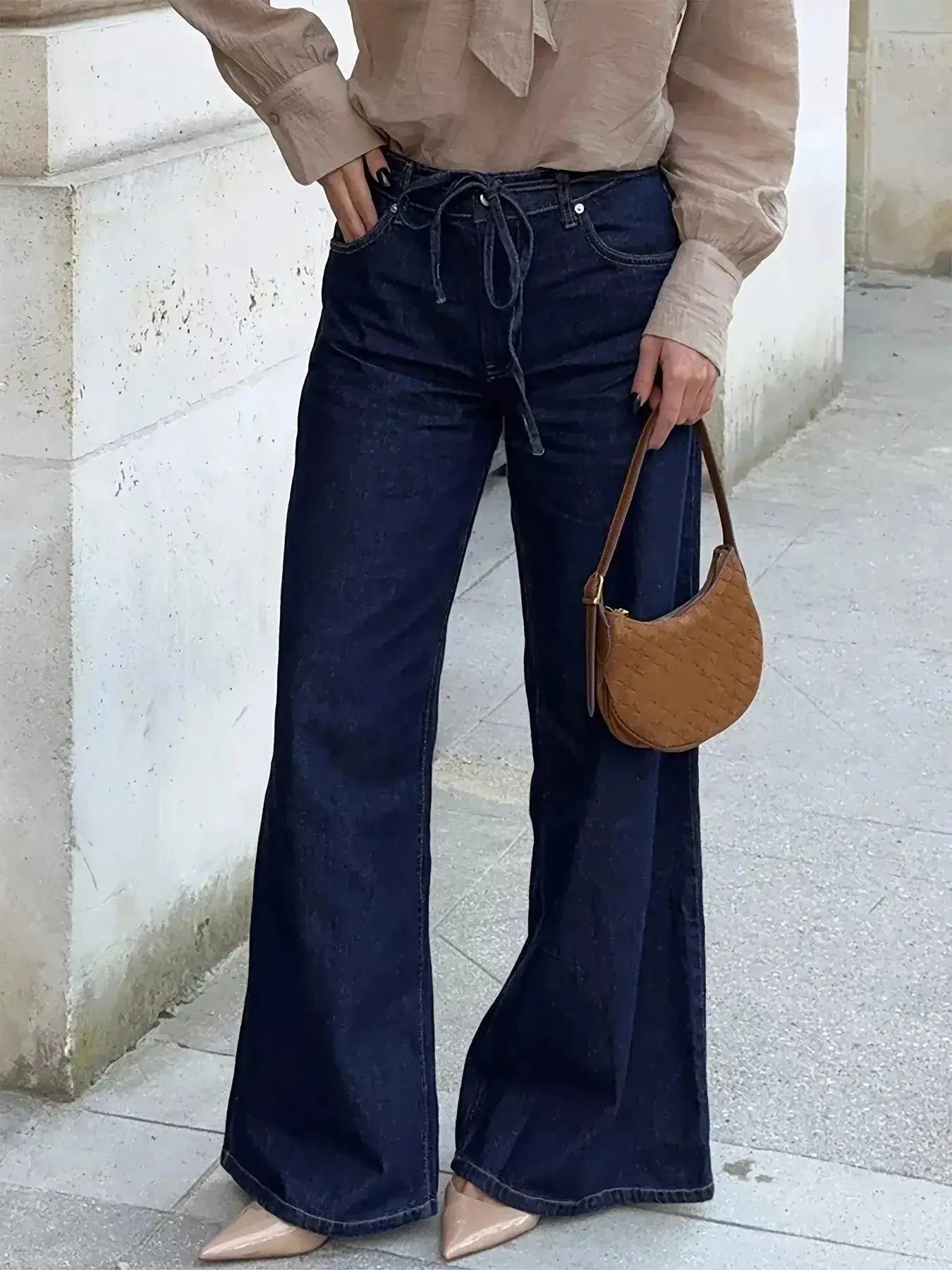 Women’s high-waisted flare jeans with tie waist and relaxed fit, made of denim, from Trendsi.