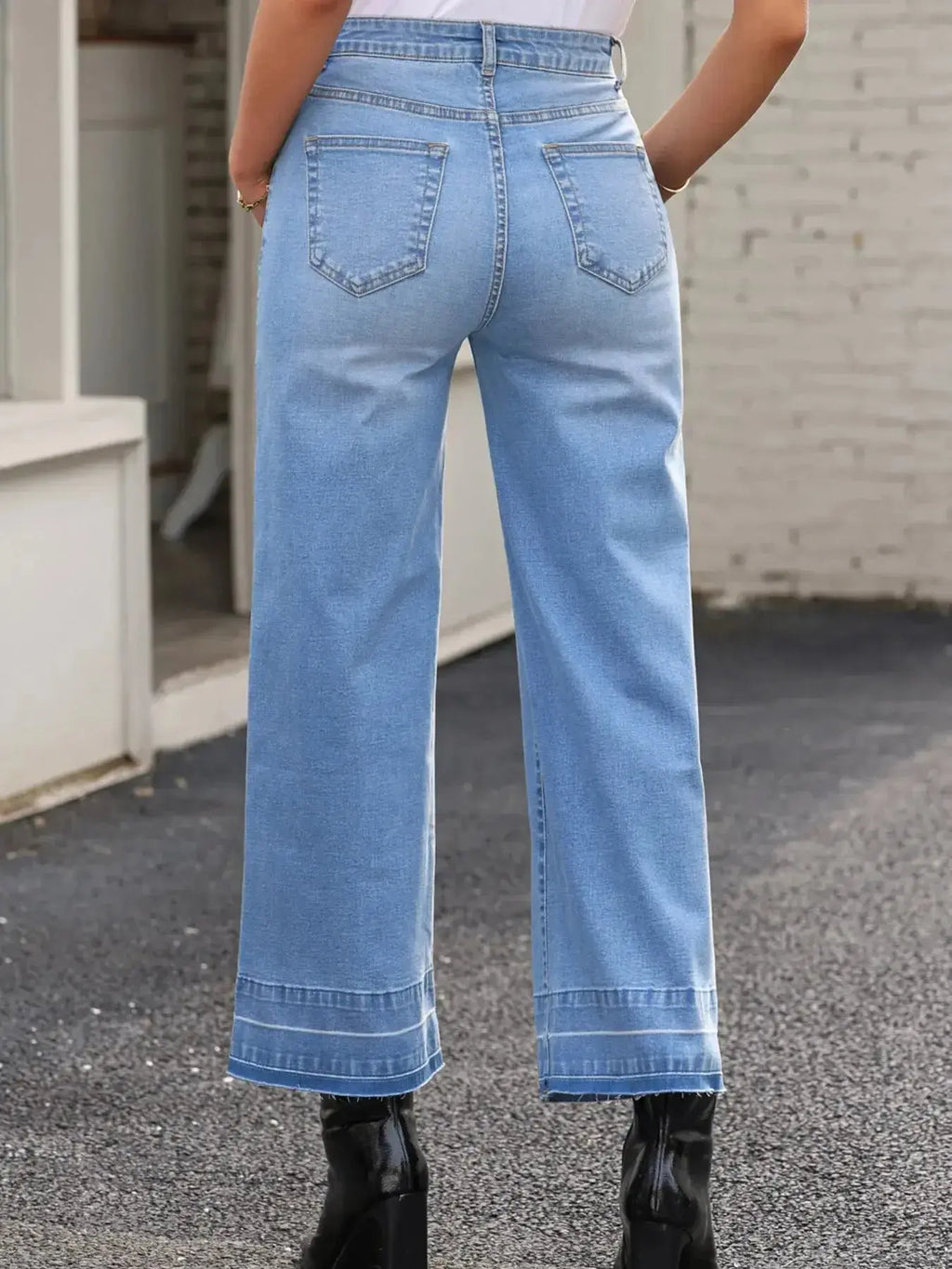 Women's high-waisted wide-leg washed denim jeans with a relaxed fit, styled casually, by Trendsi.