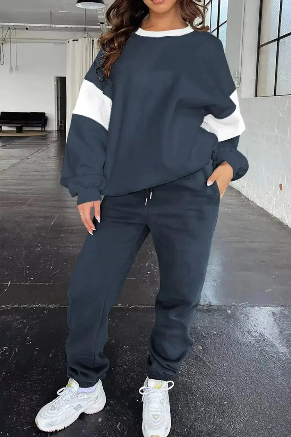 Women wearing Plush Fashion Hub oversized drop shoulder sweatshirt and matching joggers loungewear set in a cozy indoor setting.
