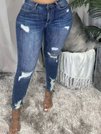 Plus size distressed slim fit jeans with raw hem by Trendsi, showing front view with faded denim and frayed edges.