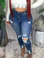 Plus size women's distressed slim fit jeans with raw hem from Trendsi, showcasing a stylish fit and raw edge detail.