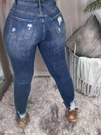Plus size women's distressed slim fit jeans with raw hem, trendy denim by Trendsi, showcasing the stylish fit and distressed details.