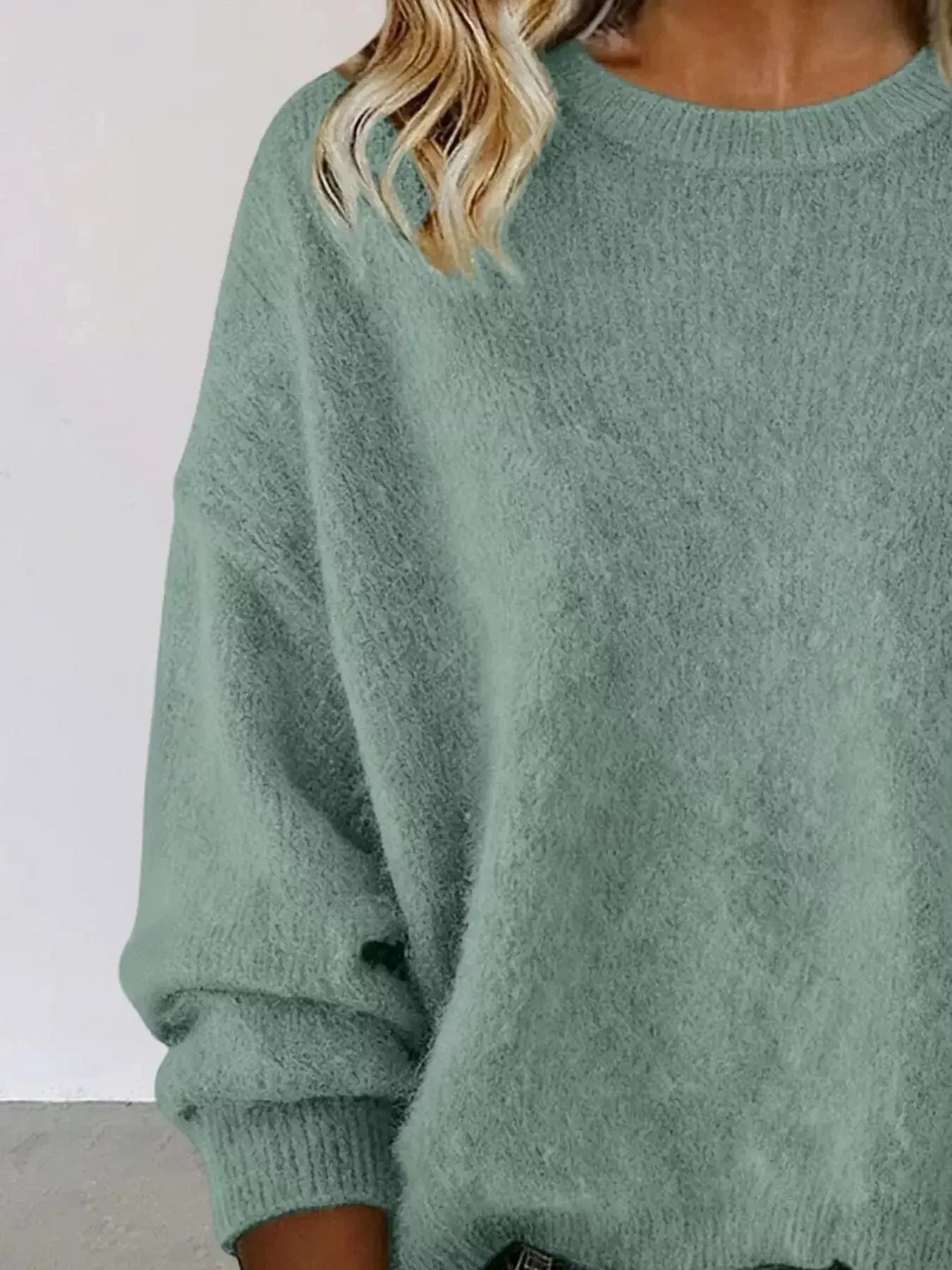 Plus size women's relaxed fit dropped shoulder round neck sweater by Trendsi, showcasing soft knit fabric and cozy style.