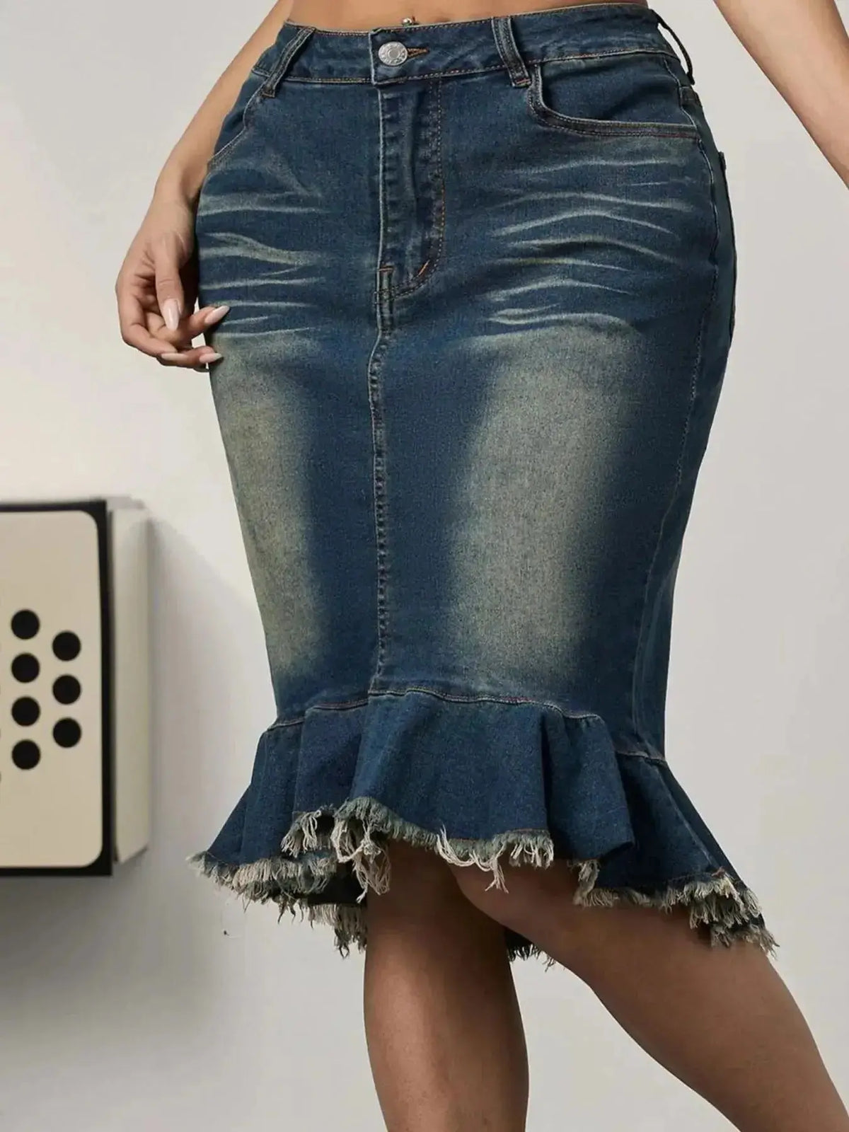 Women’s blue denim midi skirt with raw hem and mermaid silhouette, featuring stretchy fabric for a fitted look.