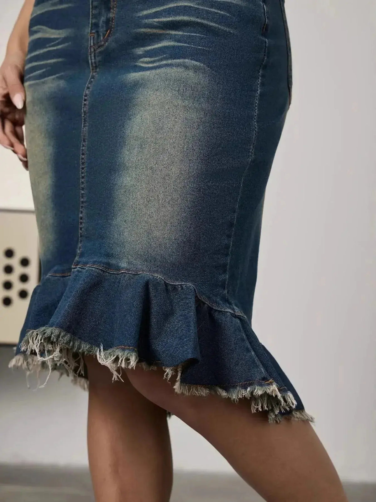 Women’s stretchy blue denim midi skirt with raw hem and mermaid silhouette, by Plush Fashion Hub.