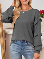 Women’s ruffled round neck ribbed long sleeve sweatshirt by Trendsi, featuring a cozy fit and stylish ruffle detail.