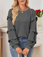Women's ruffled round neck ribbed long sleeve sweatshirt by Trendsi, featuring a stylish ruffled neckline and cozy ribbed fabric.