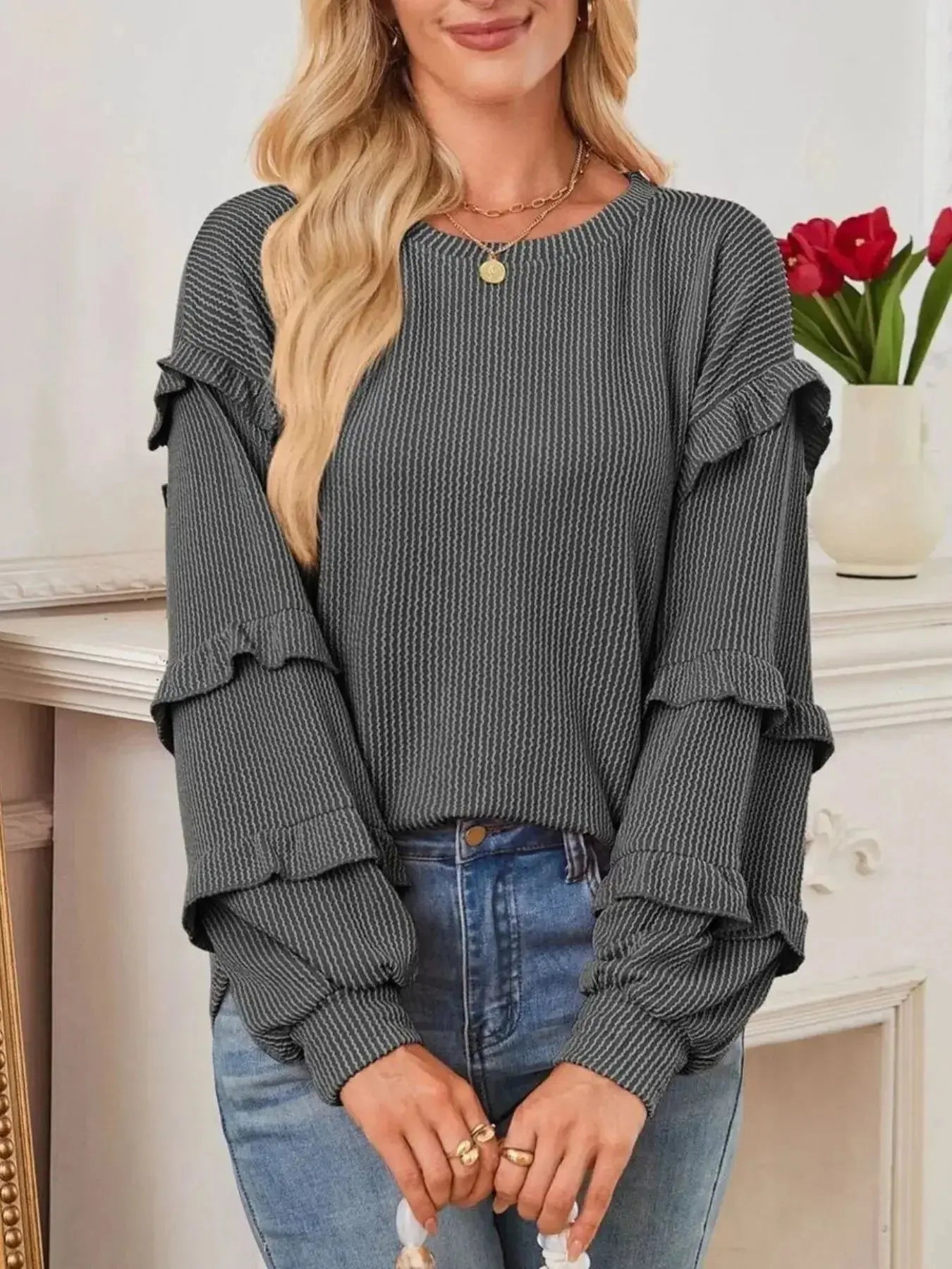 Women's ruffled round neck ribbed long sleeve sweatshirt by Trendsi, featuring a stylish ruffled neckline and cozy ribbed fabric.