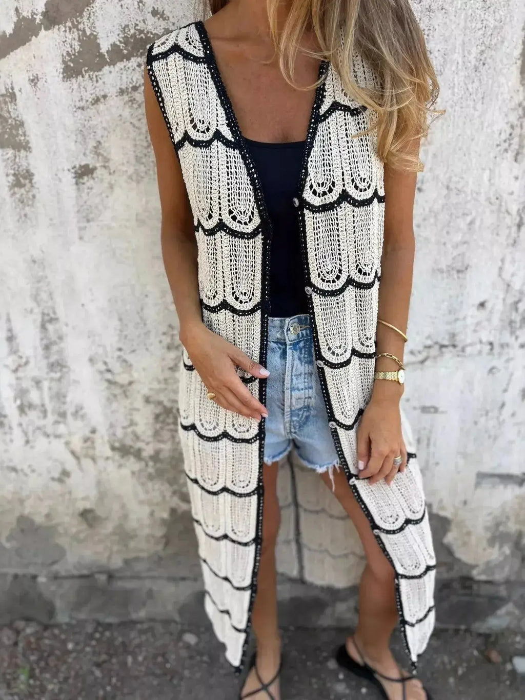 Women's sleeveless crochet longline cardigan with openwork knit design and button-front closure, stylish vest by Trendsi.
