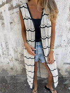 Women's sleeveless crochet longline cardigan with openwork knit design and button-front closure, stylish vest by Trendsi.