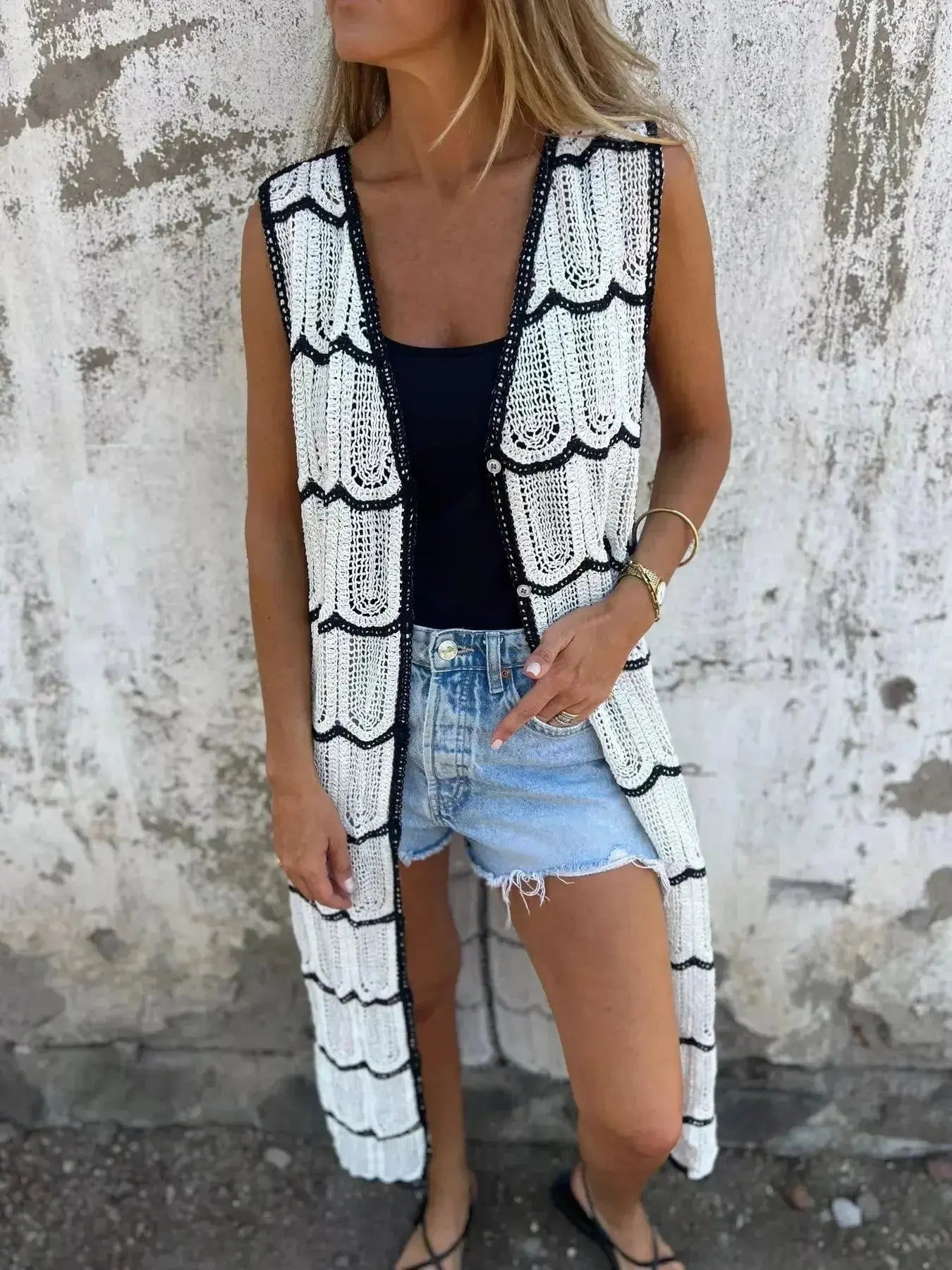 Women's sleeveless crochet longline cardigan with openwork knit and button-front design, stylish open-front sweater vest by Trendsi.