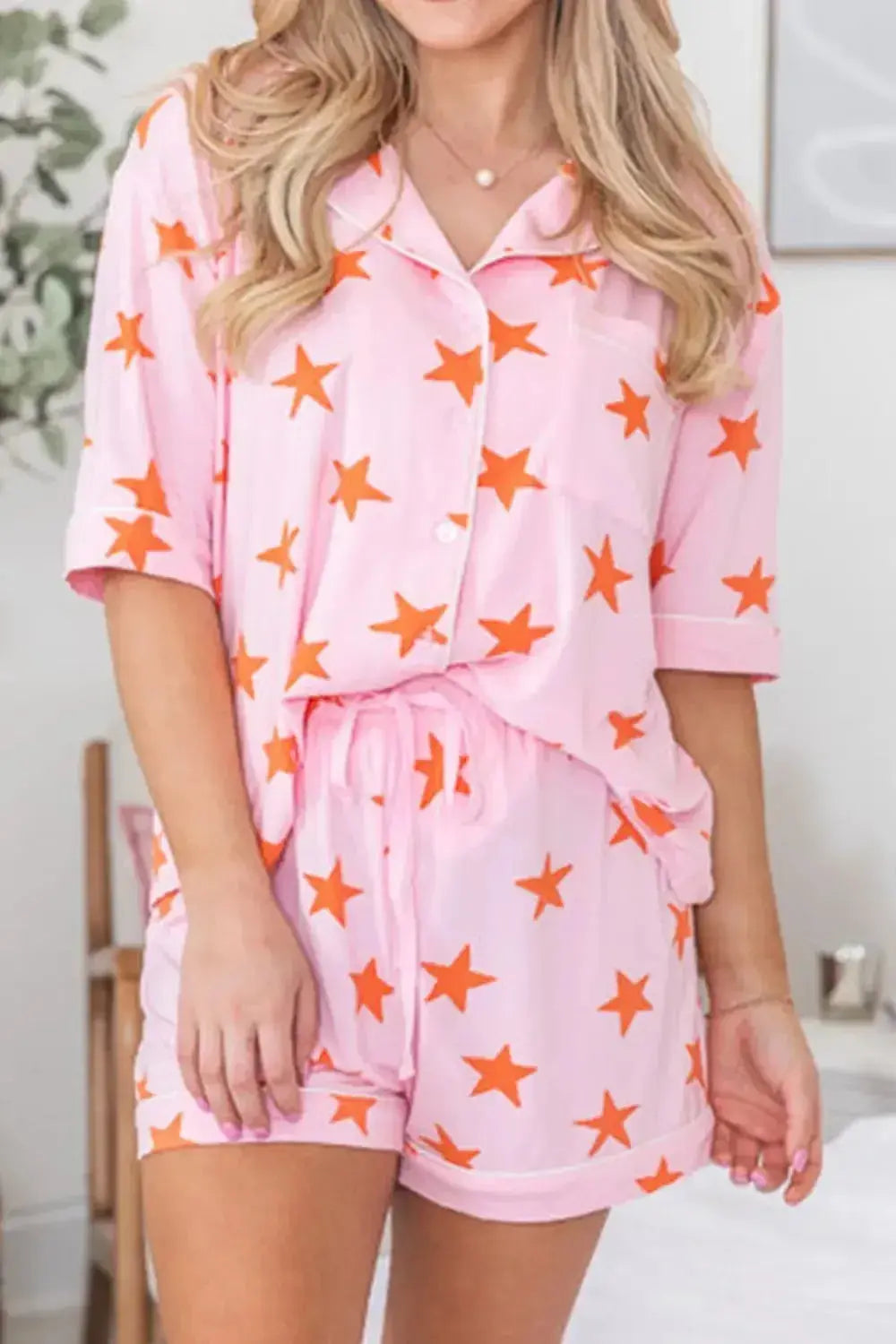 Women’s star print short sleeve button-down pajama set by Trendsi, featuring a cozy, stylish pajama top and matching shorts.