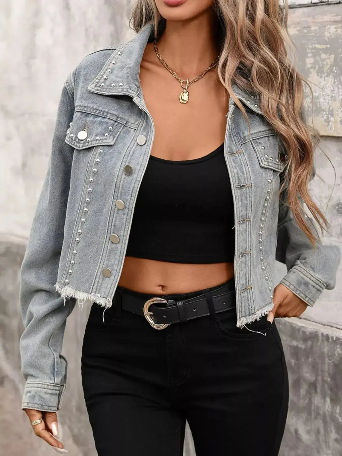 Women’s studded raw hem denim jacket in distressed blue, stylish denim jacket with metal stud accents, by Plush Fashion Hub.