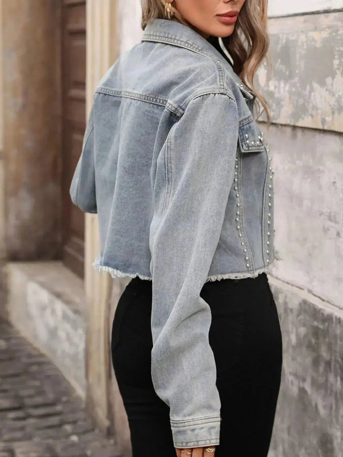 Women’s distressed blue denim jacket with studded details and raw hem, stylish and trendy from Plush Fashion Hub.