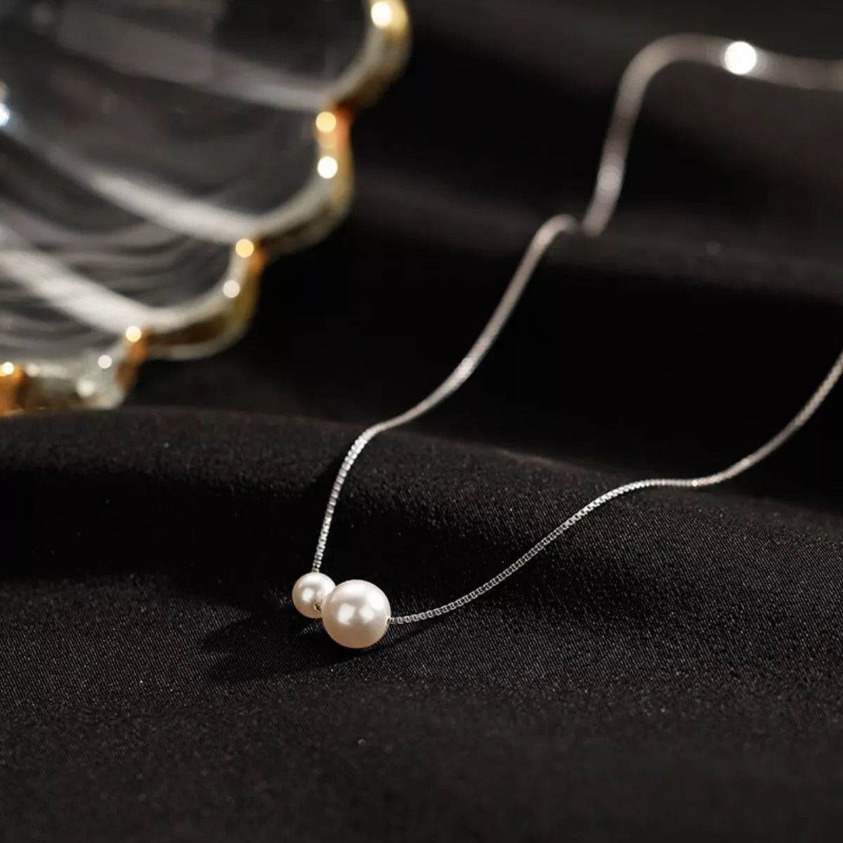 Sterling silver pearl necklace featuring a string of lustrous white pearls, elegant jewelry piece from Plush Fashion Hub.