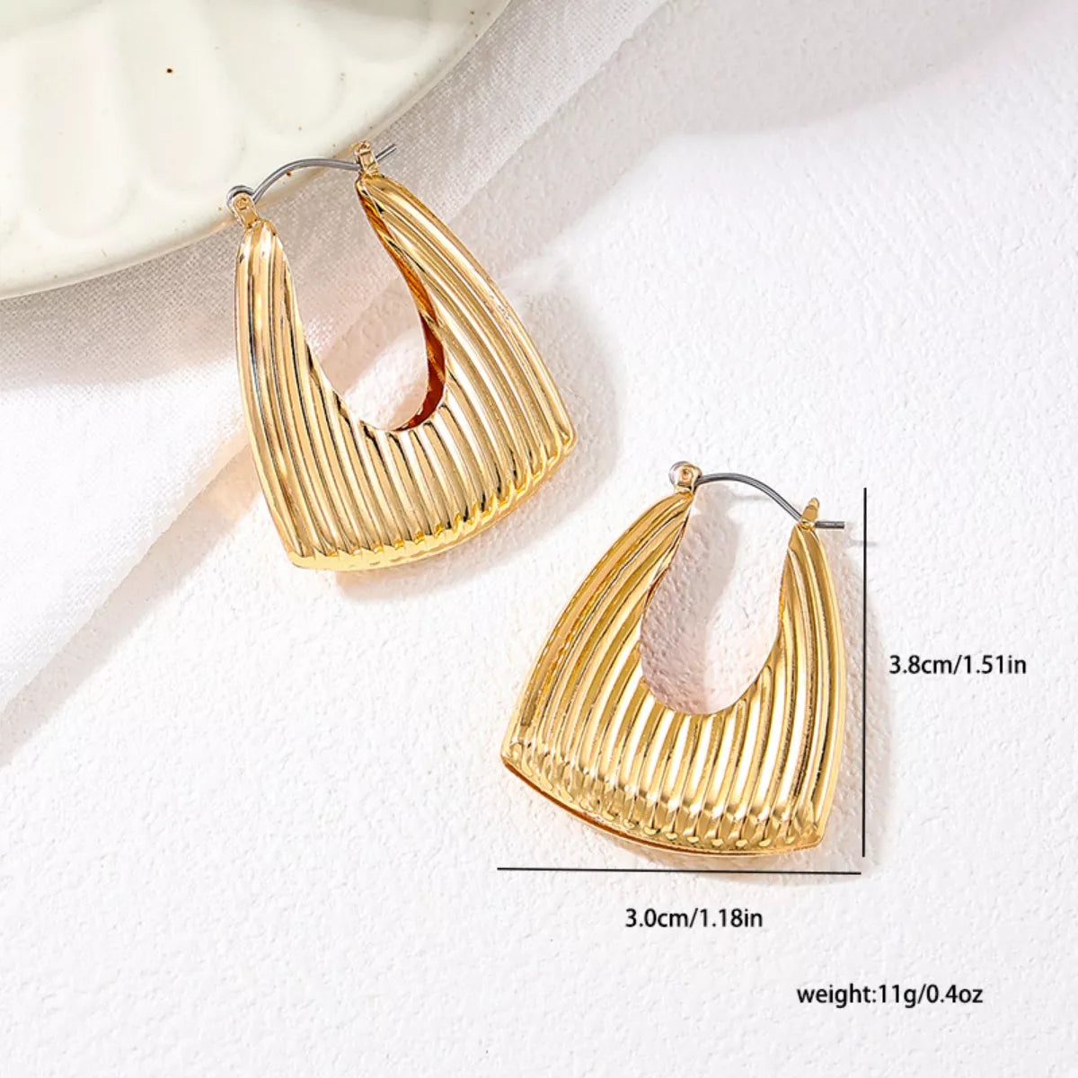 Gold-plated alloy ribbed triangular hoop earrings with a sleek design, perfect for stylish accessorizing.