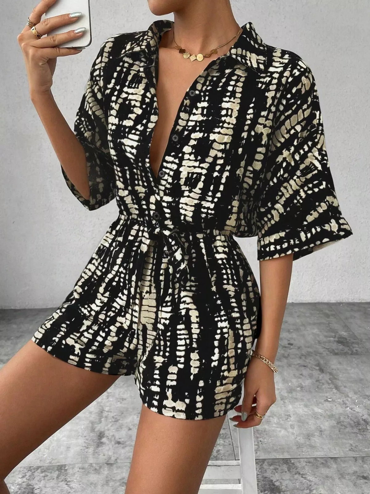 Striped button-up belted romper jumpsuit by Plush Fashion Hub, featuring a stylish design and waist tie detail.