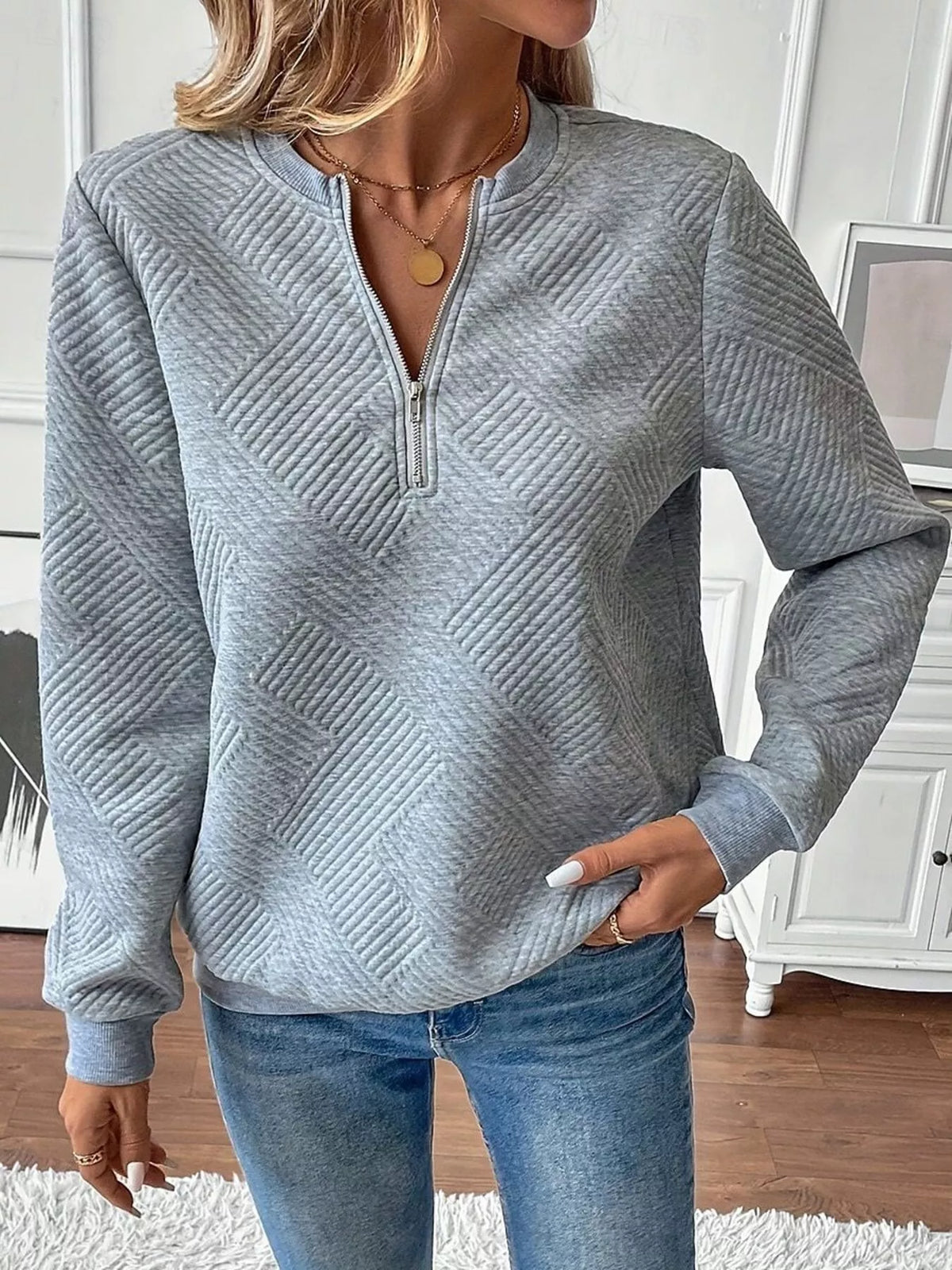 Textured women's quarter-zip sweatshirt by Trendsi, featuring a close-up of the fabric and quarter-zip detail.