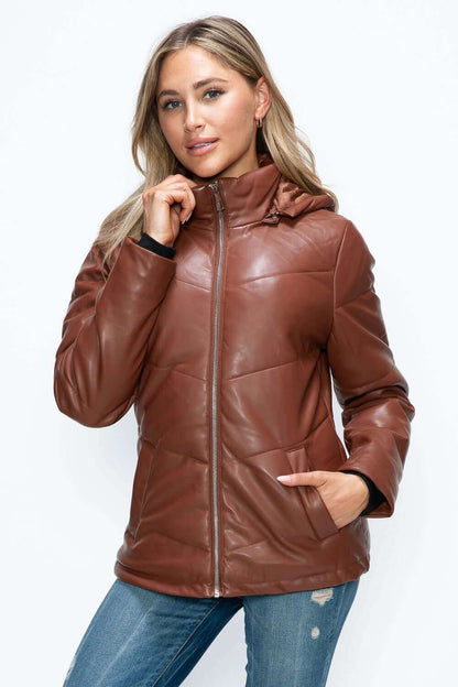 Pocketed zip-up brown puffer jacket with removable hood worn by model.