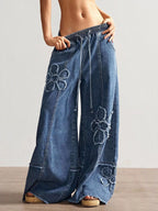Shopimist floral appliqué wide leg jeans showing embroidered floral details on light denim with a relaxed fit.