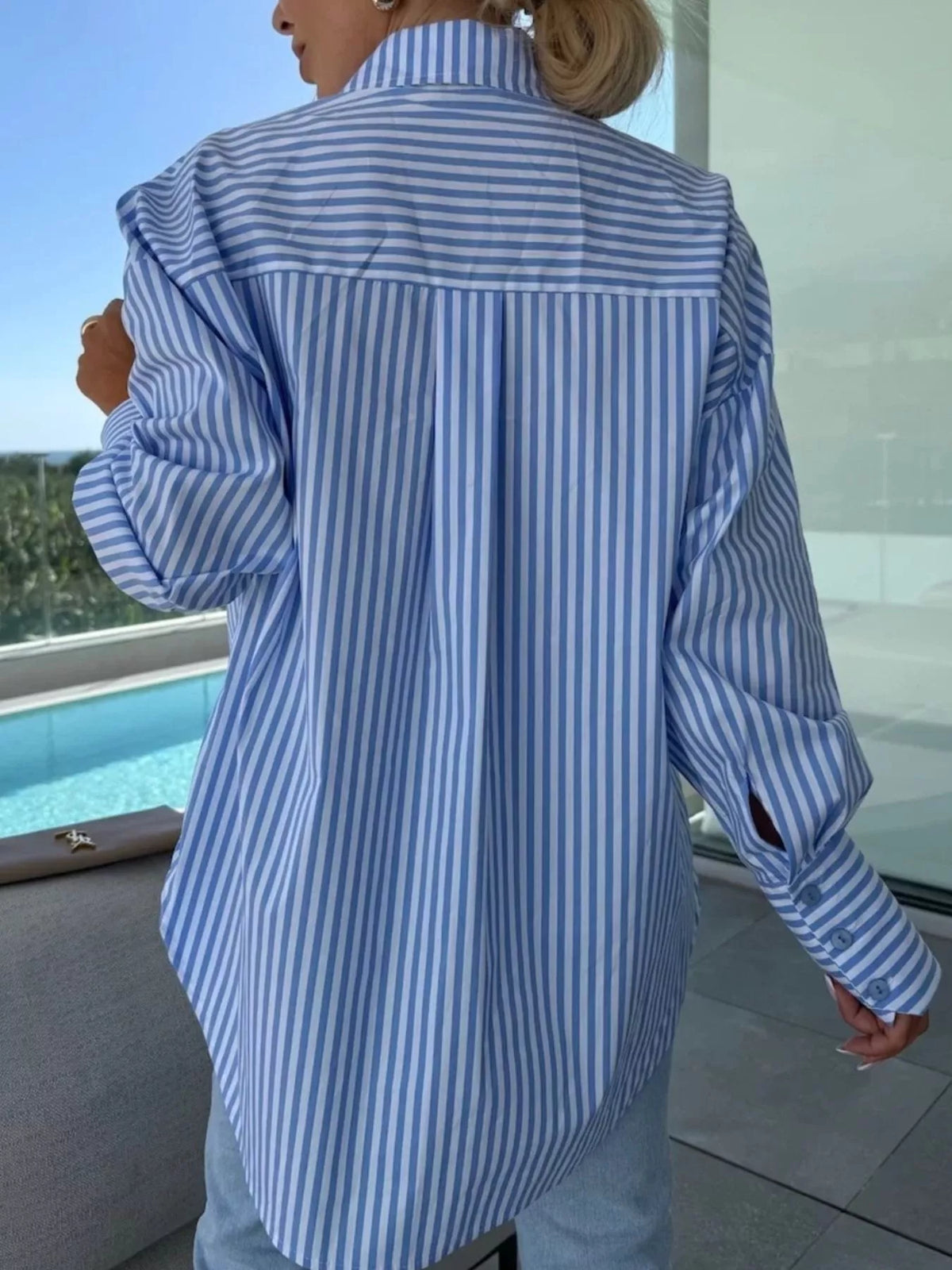 Women's long sleeve striped button-up shirt by Trendsi, featuring a classic design with vertical stripes and a collar.