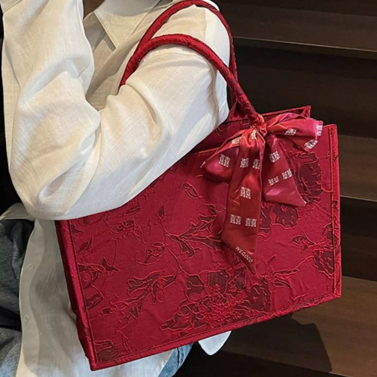 Floral embossed tote handbag with scarf accent by Plush Fashion Hub, featuring textured floral pattern and stylish accessory detail.
