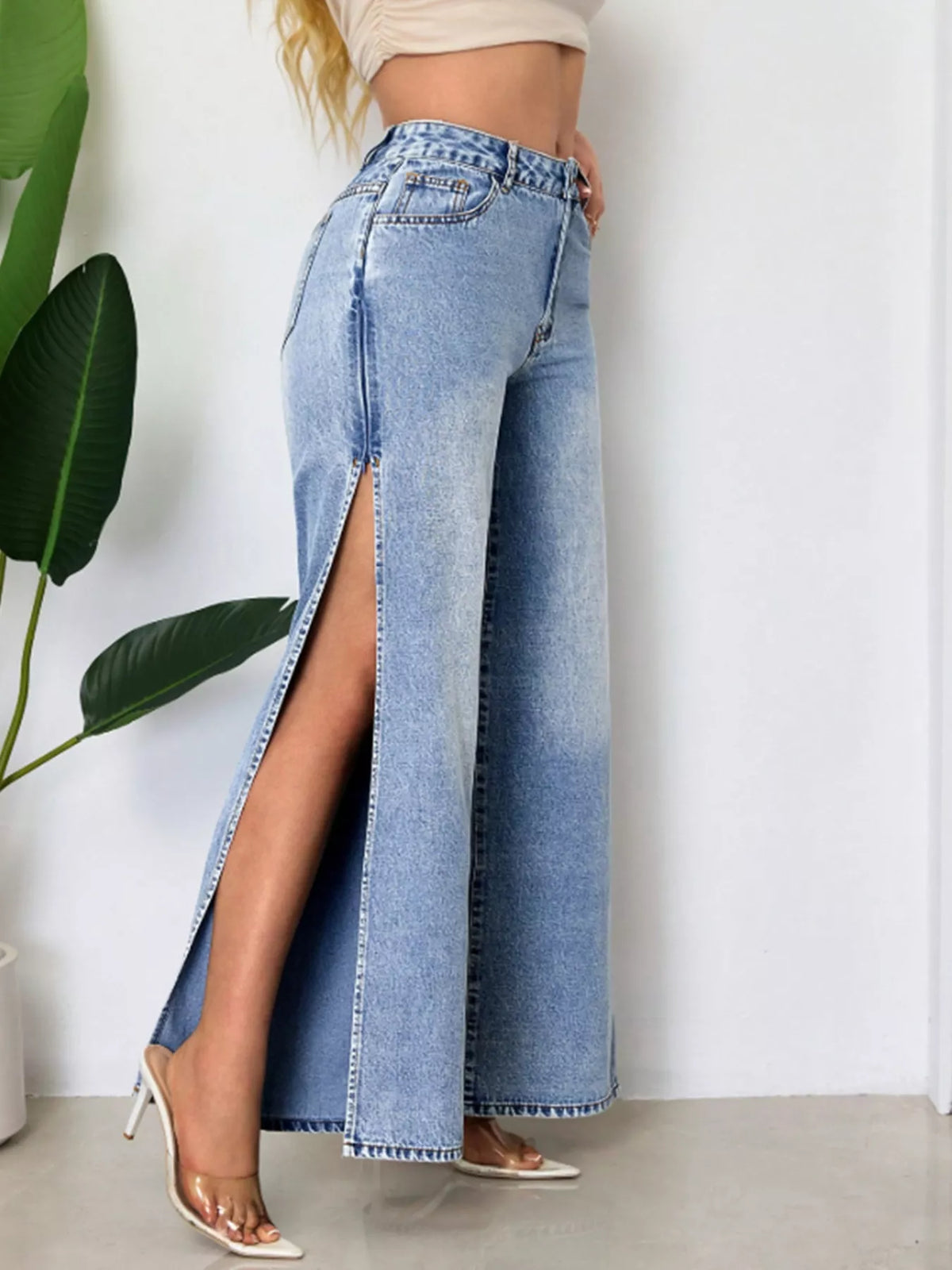 High-waisted wide-leg denim jeans with side slits from Trendsi, featuring a relaxed fit and stylish design.