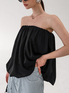 Women's strapless bubble hem tube top by Trendsi, featuring a sleek minimalist design, perfect for trendy, minimalist fashion.
