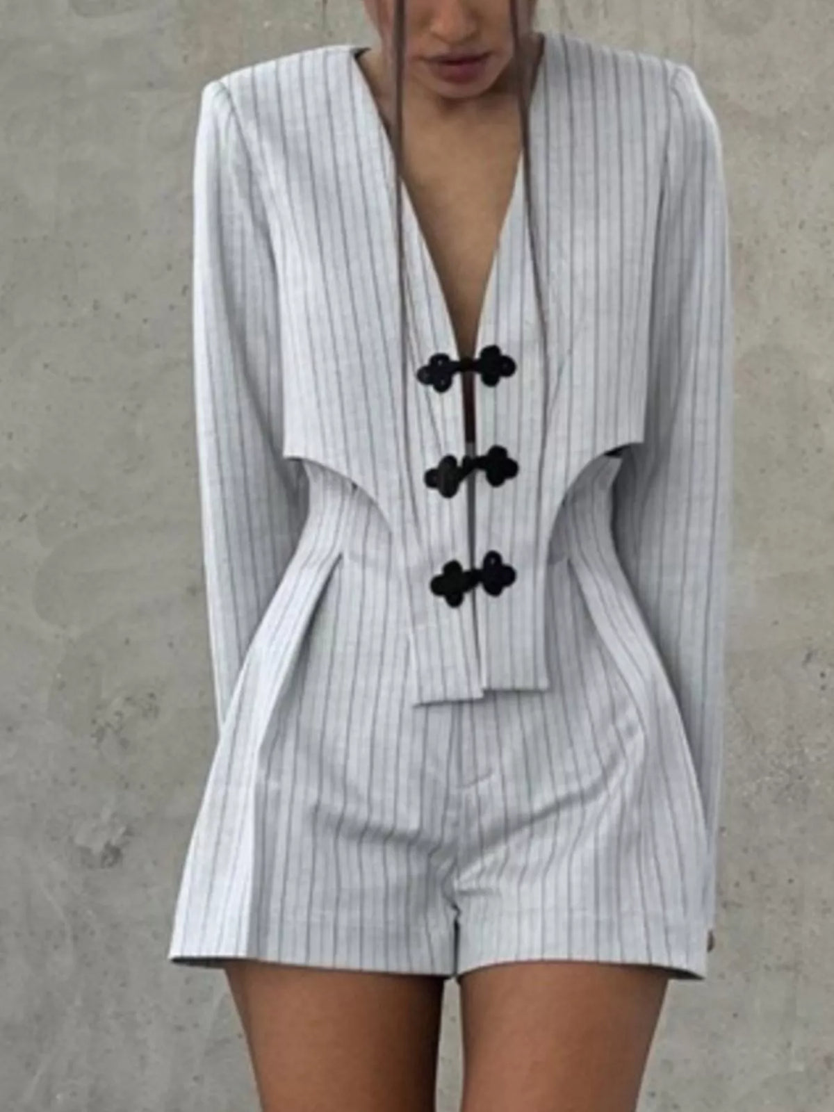Pinstripe cropped blazer and pleated shorts set by Trendsi, featuring tailored blazer and stylish matching shorts.