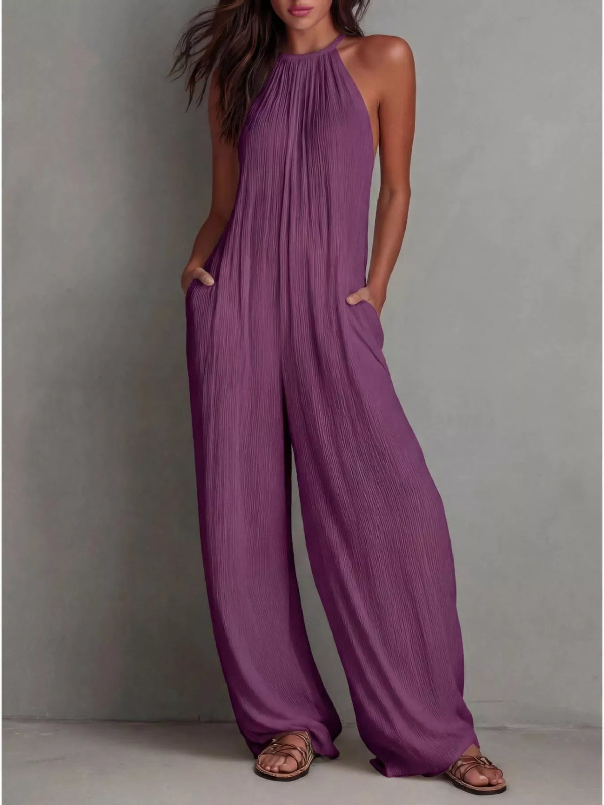 Sleeveless wide-leg jumpsuit from Plush Fashion Hub, displayed on a hanger with a neutral background and flowing fabric.