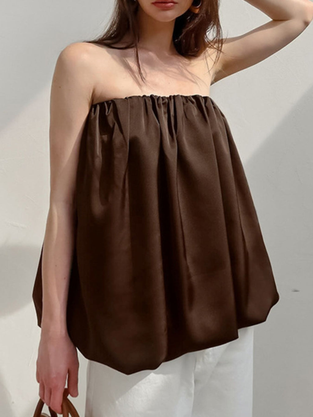 Women's strapless bubble hem tube top by Trendsi, featuring a sleek minimalist design in a trendy crop top style.